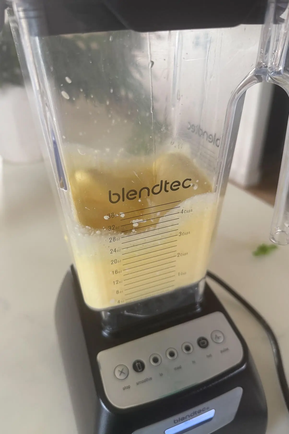 The pancake batter mid-blend in a Blendtec blender, showing a creamy consistency and light yellow color from the cottage cheese and eggs.